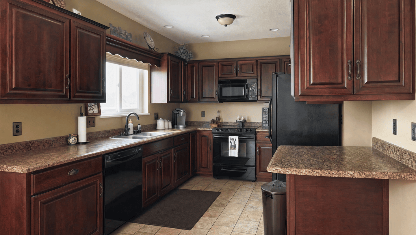 Dark cherry kitchen cabinets before refinishing in Fremont
