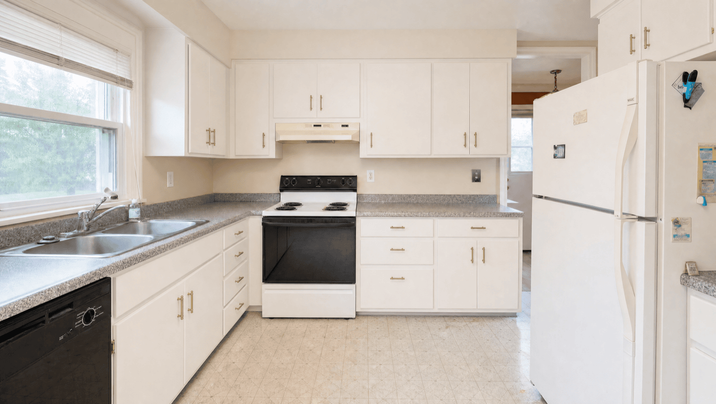 Same Oakland kitchen after cabinets refinished warm white with brass